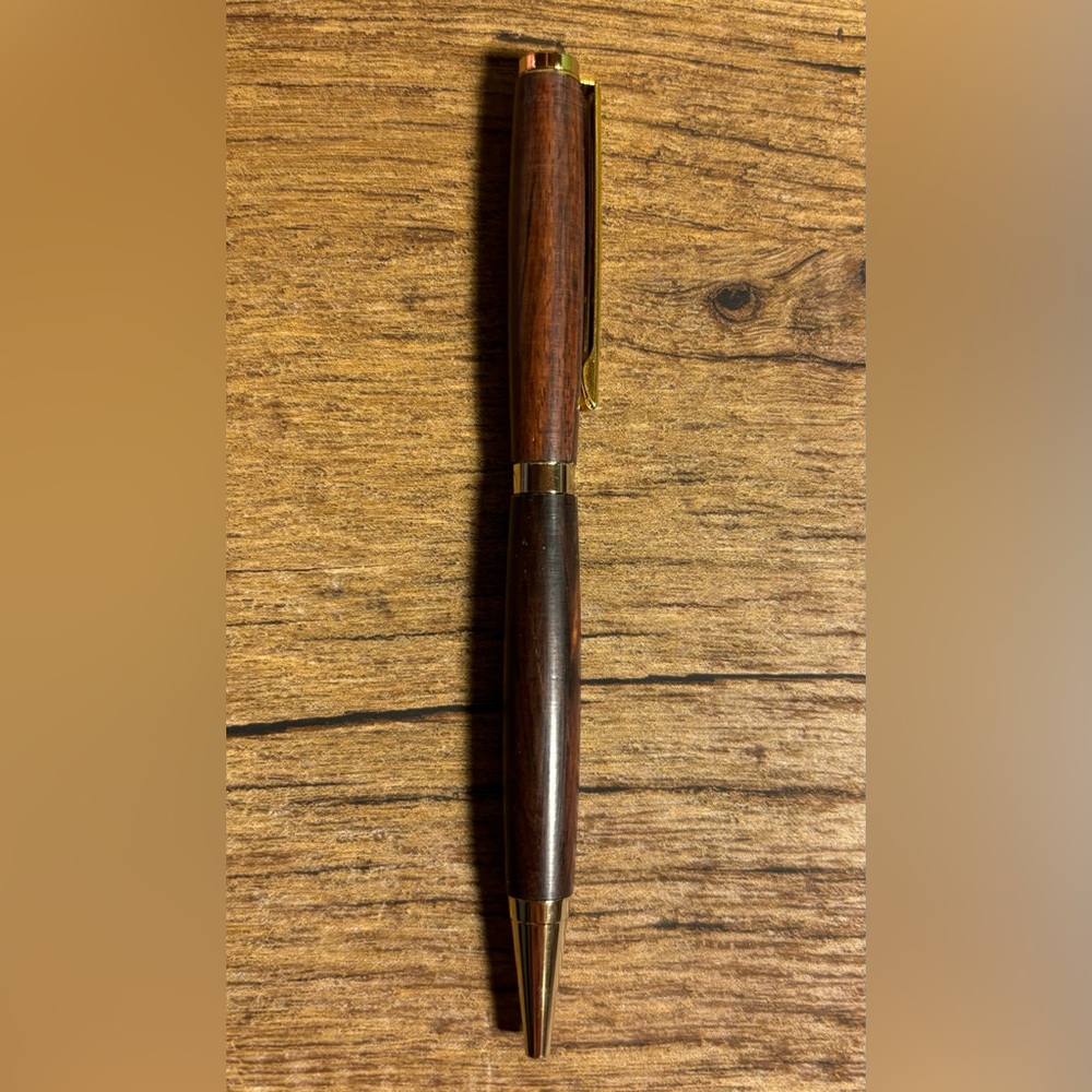 Hand turned 2 tone wood ink pen. Smooth writing black ink. Gold accents.